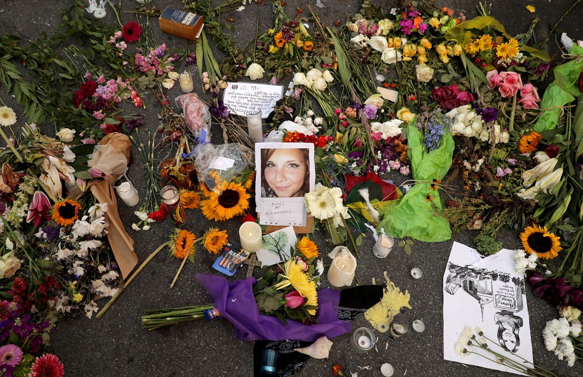 Flowers, candles, and chalk-written messages surround a photograph of Heather Heyer on the spot where she was killed and 19 others injured when a car slammed into a crowd of people protesting against a white supremacist rally on August 16th, 2017, in Charlottesville, Virginia.