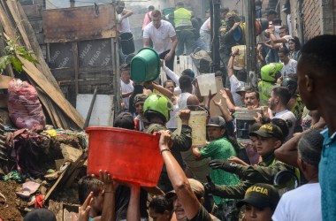 Local residents and policemen fight a huge fire in the Moravia neighborhood in Medellin on August 18th, 2017. The Moravia sector is known for having been built on a garbage dump and for being the base for late drug lord Pablo Escobar's first political campaign and where he helped to build a football field and to install the electric network.