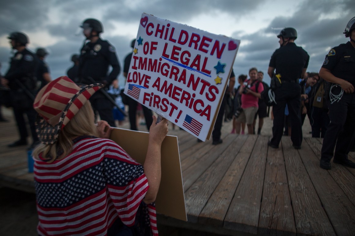 A demonstrator holds a sign during an America First rally on August 20th, 2017, in Laguna Beach, California.