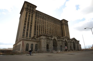 A man rides his bike past the shuttered Michigan Central Railroad Station November 20th, 2008, in Detroit, Michigan.