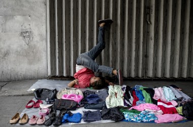 A street vendor stretches as she waits for customers along a street in Manila on August 23rd, 2017.