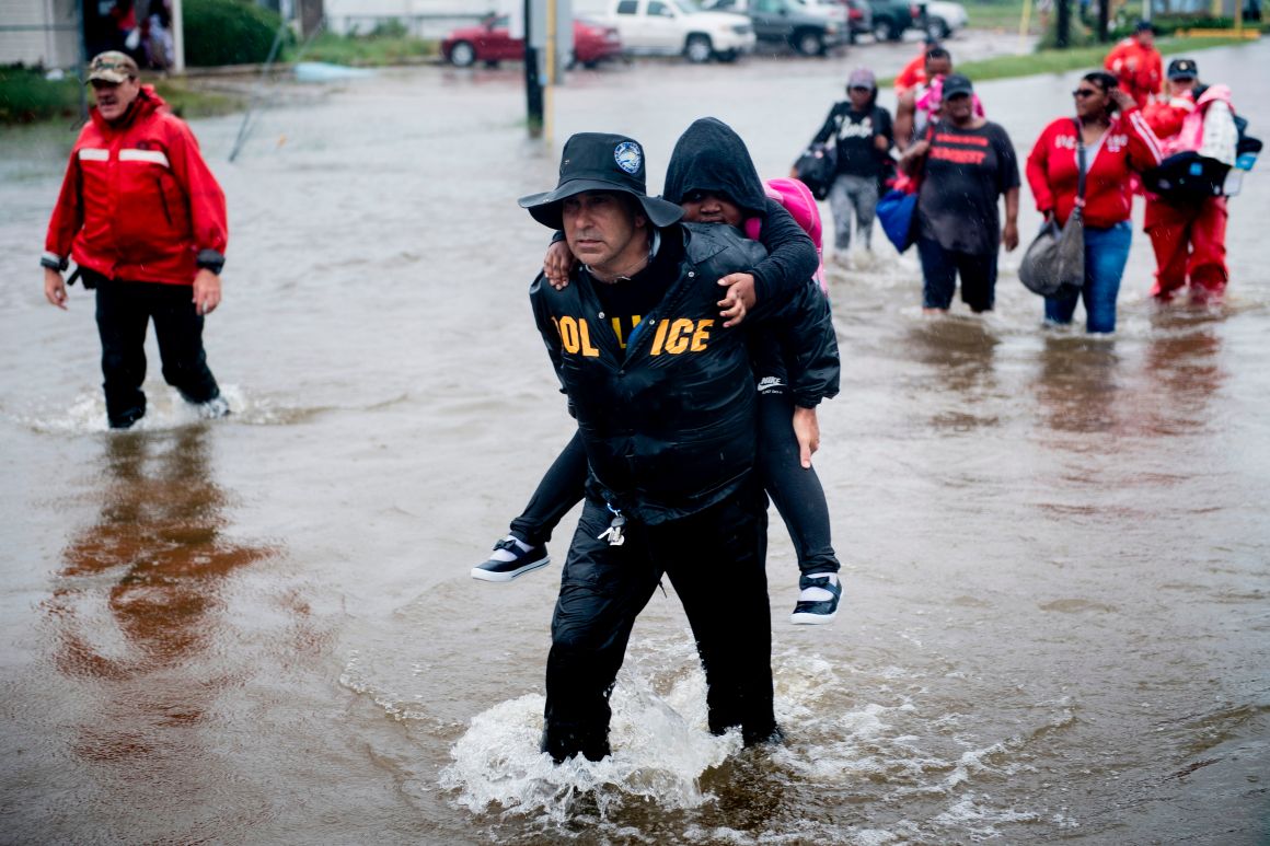 People walk to a Harris County Sheriff air boat while escaping a flooded neighborhood during the aftermath of Hurricane Harvey on August 29th, 2017, in Houston, Texas. Hurricane Harvey has set what forecasters believe is a new rainfall record for the continental United States, officials said Tuesday.