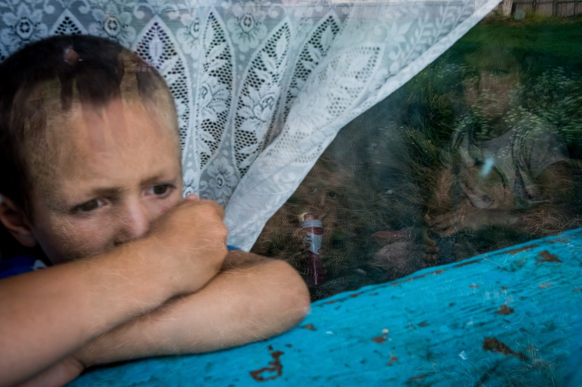 Children living in a house without electricity look out the window, July 24th, 2017, in the village of Gorbanesti, Romania.