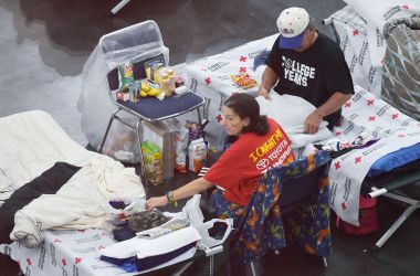 People sit on cots in the George R. Brown Convention Center which has been a shelter for evacuees from Hurricane Harvey in Houston on September 2nd, 2017.