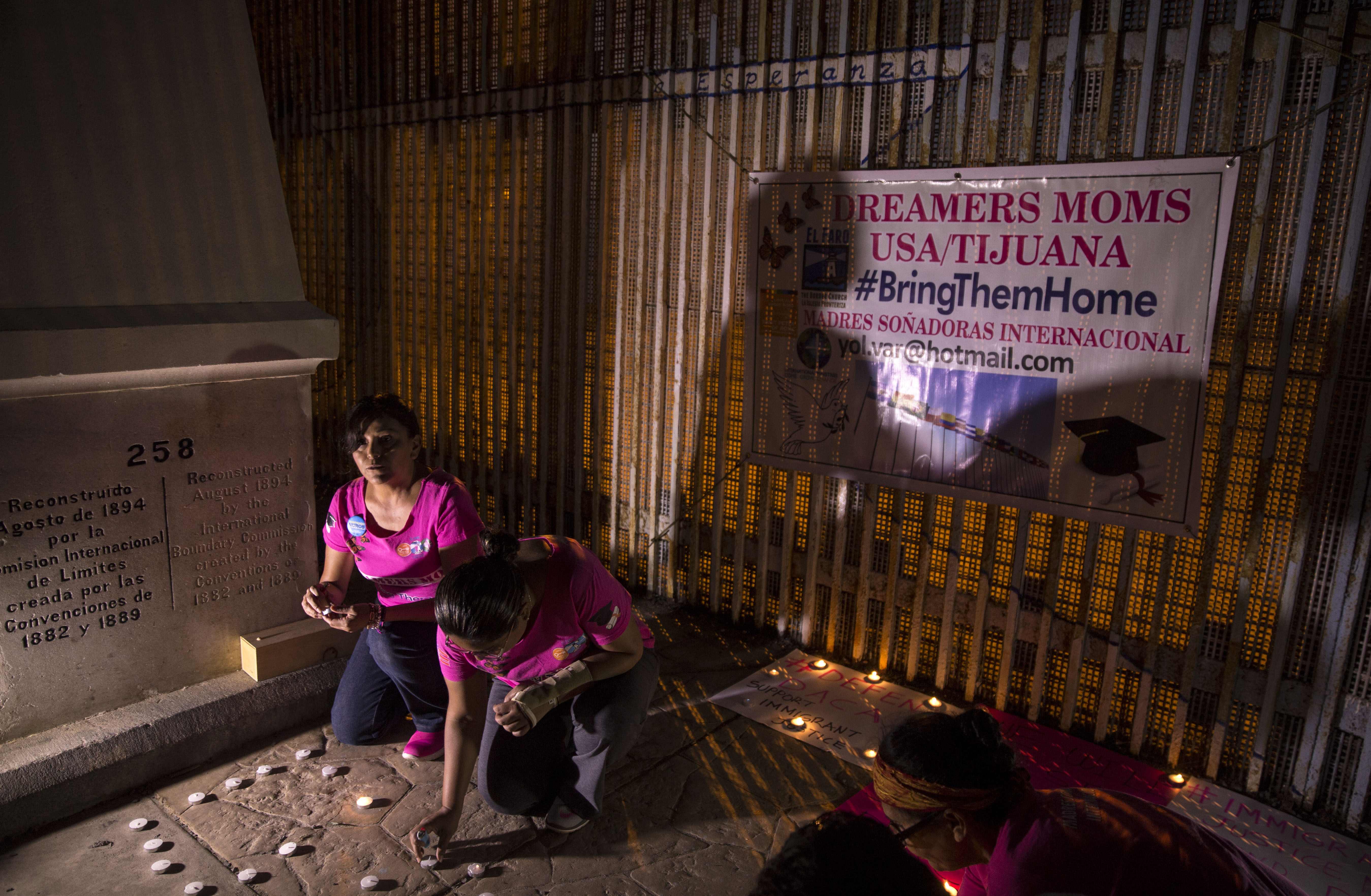 Activists pray at the wall between Mexico and the United States in Baja California, Mexico, during a protest against the possibility of deportation of those included in the DACA program on September 4th, 2017.