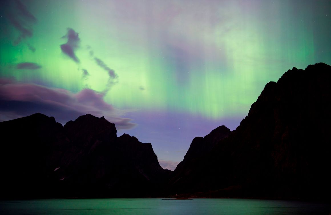 Northern lights (aurora borealis) illuminate the sky over Reinfjorden in Reine, on Lofoten Islands, Arctic Circle, on September 8th, 2017.