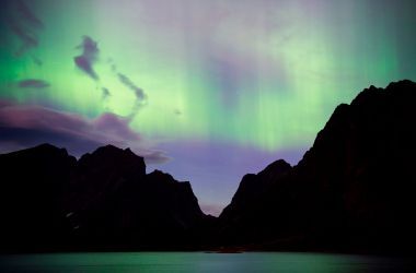 Northern lights (aurora borealis) illuminate the sky over Reinfjorden in Reine, on Lofoten Islands, Arctic Circle, on September 8th, 2017.