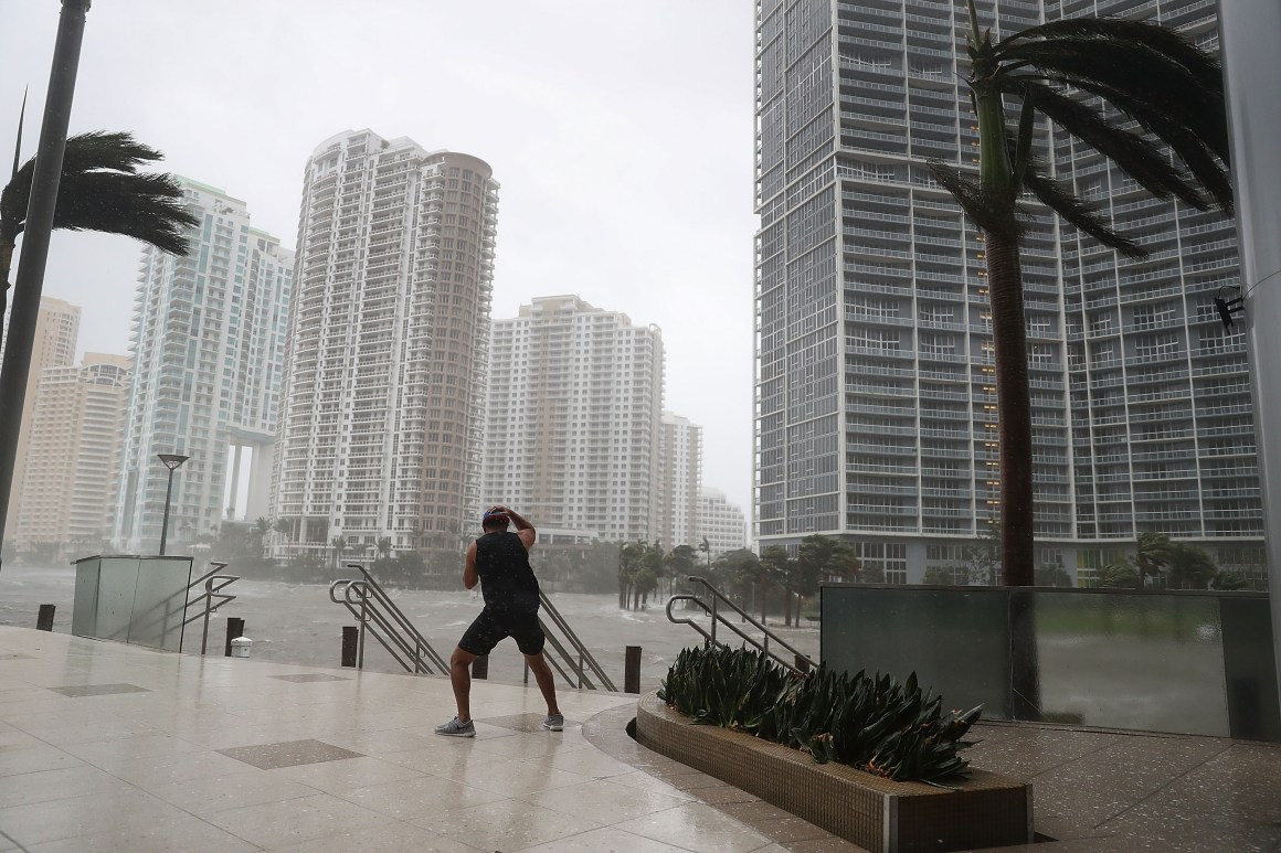 A person battles high winds and rain to take pictures of the flooding along the Miami River as Hurricane Irma passes through on September 10th, 2017, in Miami, Florida.