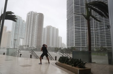 A person battles high winds and rain to take pictures of the flooding along the Miami River as Hurricane Irma passes through on September 10th, 2017, in Miami, Florida.