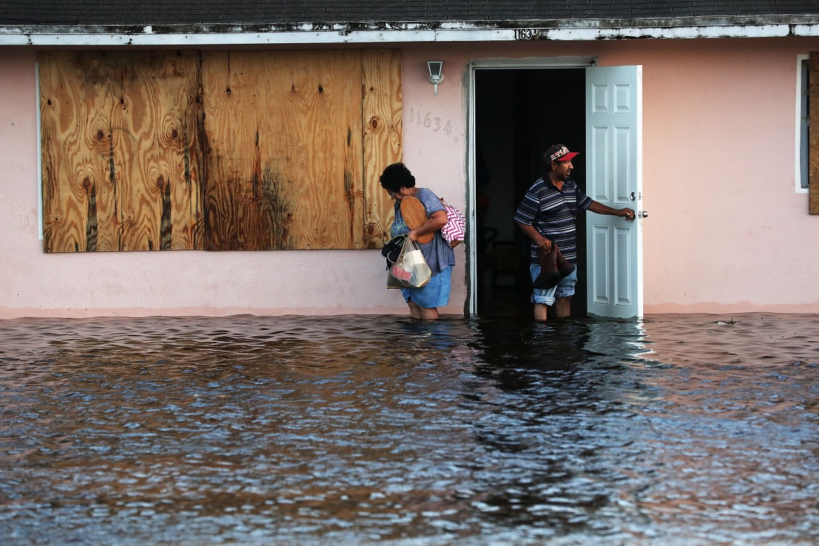 A couple leave their flooded home the morning after Hurricane Irma swept through the area on September 11th, 2017, in Fort Myers, Florida.