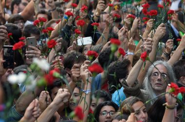 People hold flowers during a protest near the Economy headquarters of Catalonia's regional government in Barcelona on September 20th, 2017.