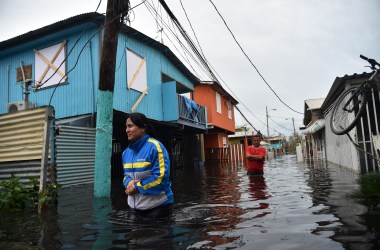 People walk across a flooded street in Juana Matos, Puerto Rico, on September 21st, 2017.