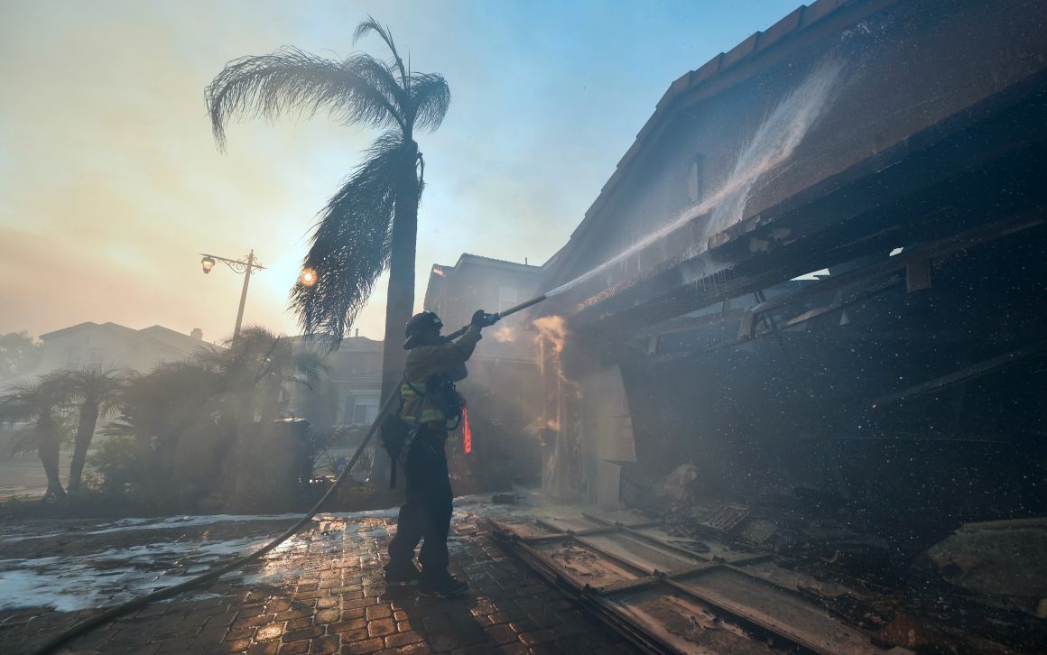 A fireman puts out a fire at a home in the Anaheim Hills neighborhood in Anaheim, California, on October 9th, 2017.