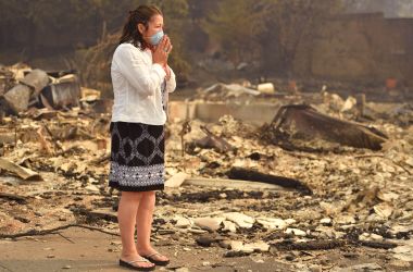 A woman looks at the wreckage of her burned home in Santa Rosa, California, on October 10th, 2017. Firefighters were battling 17 large wildfires, which have left at least 13 people dead, thousands homeless, and ravaged the state's wine country.