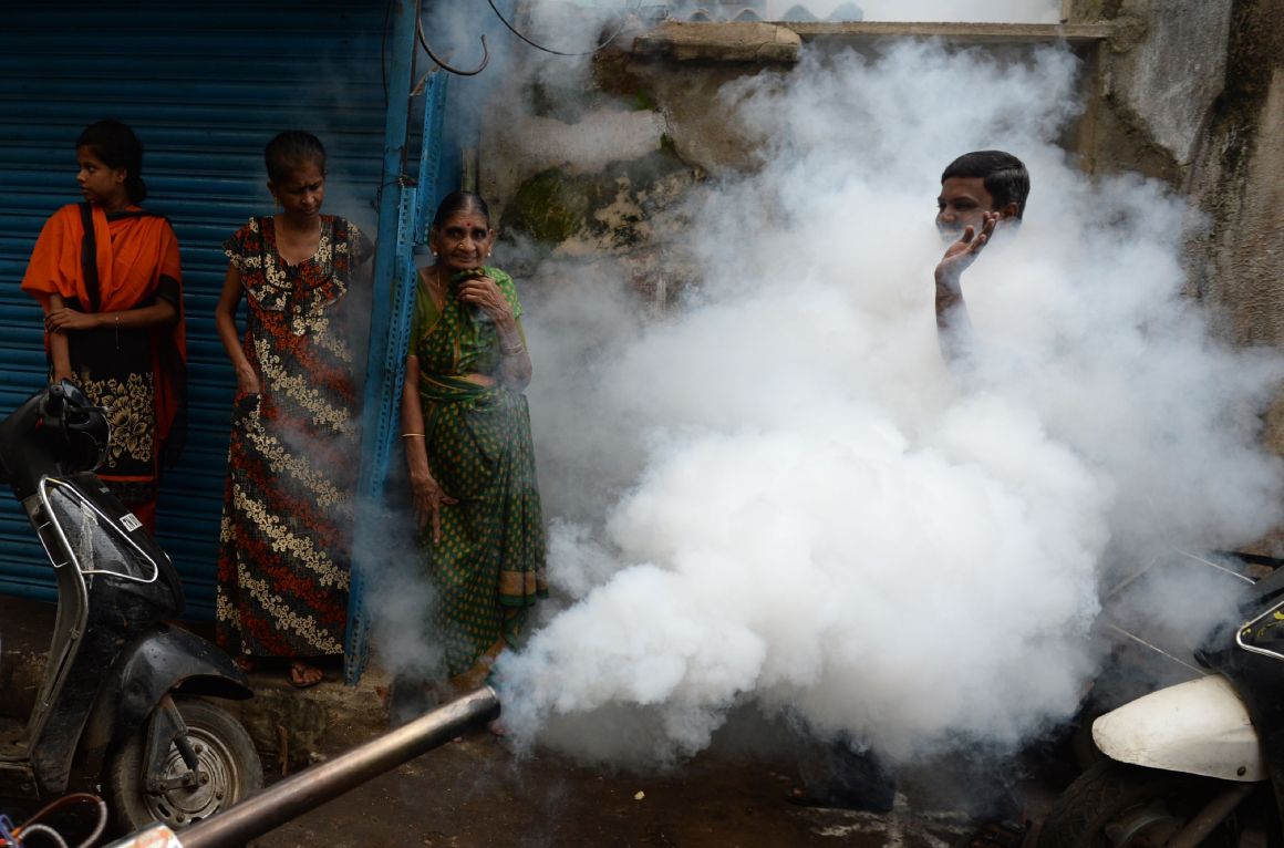 A man gestures while a municipal worker fumigates the area to prevent mosquitos from breeding in Chennai, India, on October 12th, 2017. Several cases of the mosquito-borne virus dengue have been reported from the state capital and adjoining areas, officials said, with 27 disease-related deaths reported in Tamil Nadu state.