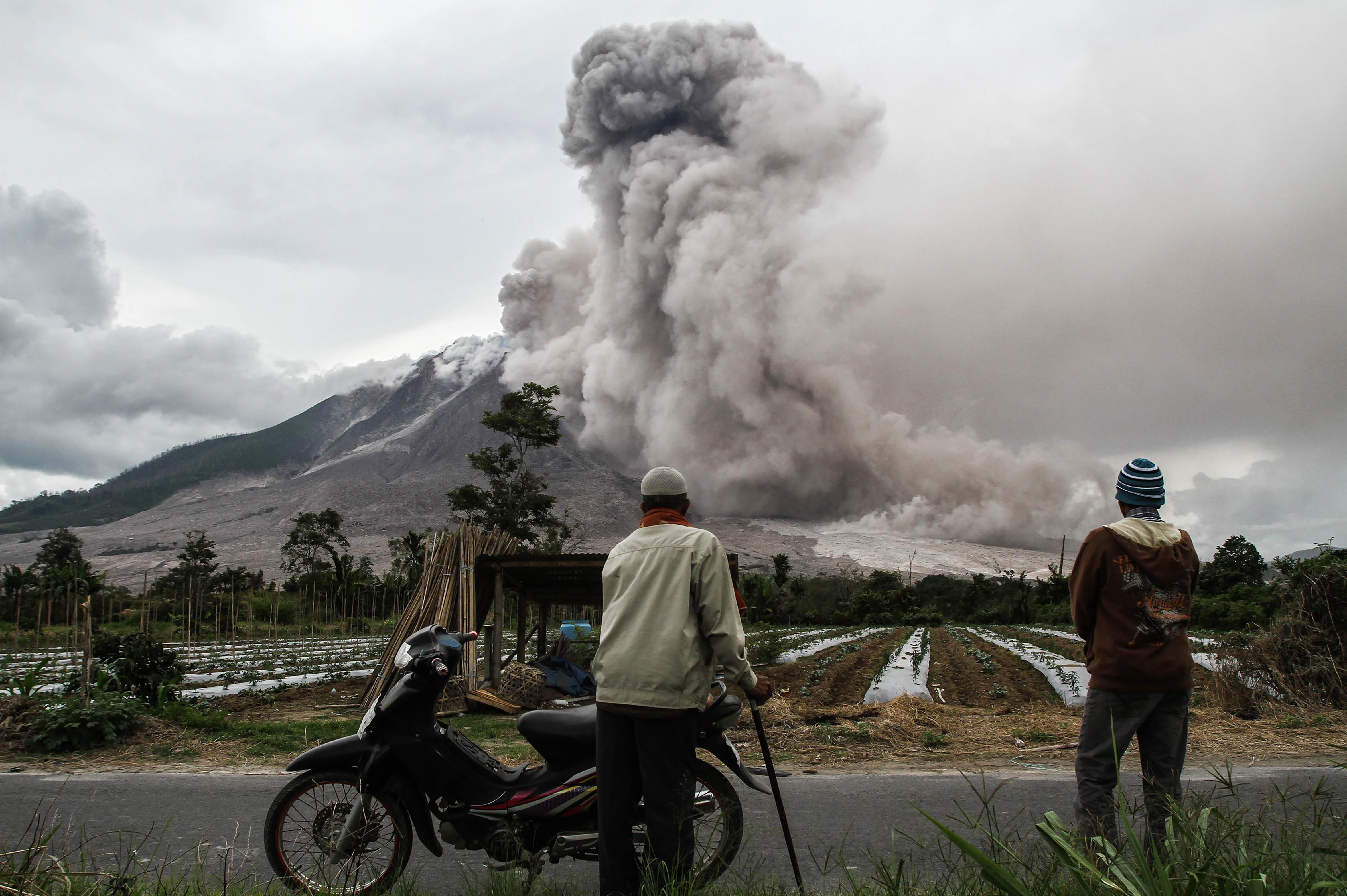 Indonesian villagers watch as Mount Sinabung volcano erupts in Karo, North Sumatra, on October 24th, 2017. Sinabung roared back to life in 2010 for the first time in 400 years and has remained highly active since.