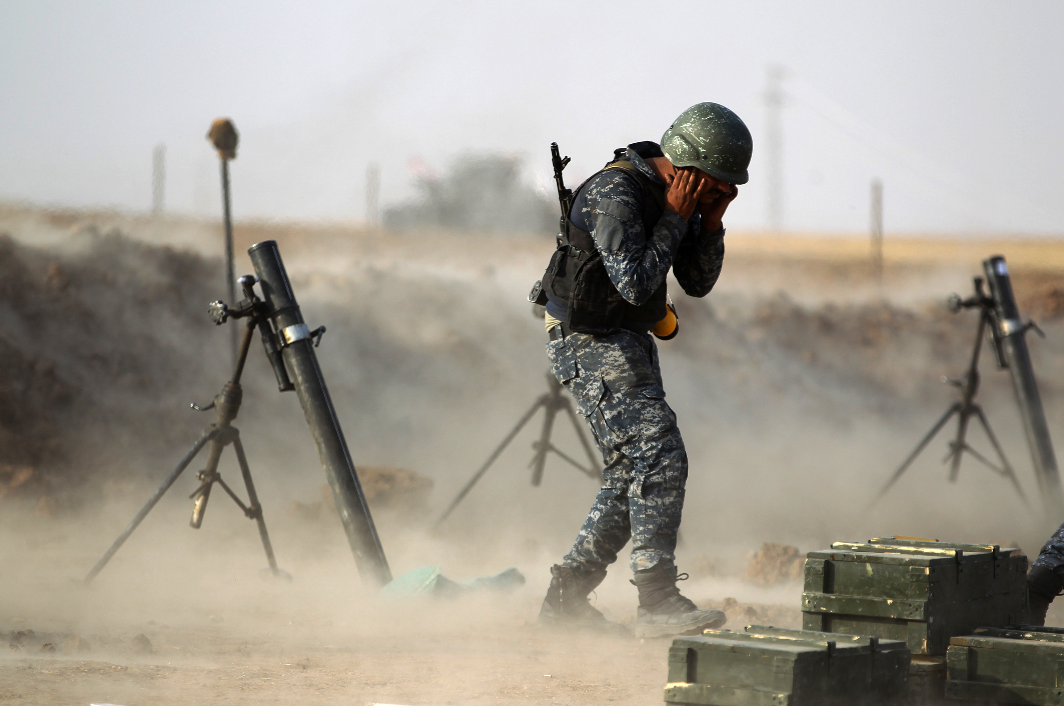 A member of the Iraqi forces covers his ears as he fires a mortar against Kurdish Peshmerga positions near the Turkish and Syrian borders in the Iraqi Kurdish autonomous region on October 26th, 2017.