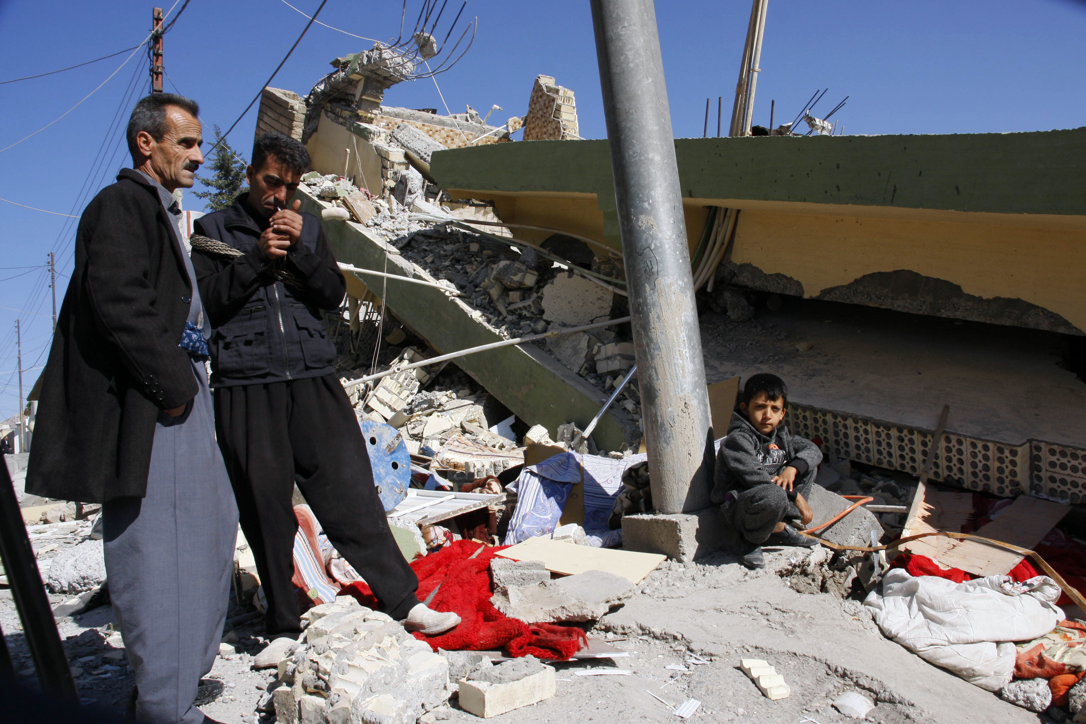 People gather around a leveled building in Darbandikhan in Iraqi Kurdistan on November 13th, 2017.