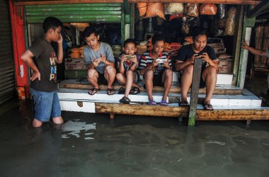 Indonesian youths play at a game center surrounded by floodwaters after seasonal rains hit Bandung on November 17th, 2017.