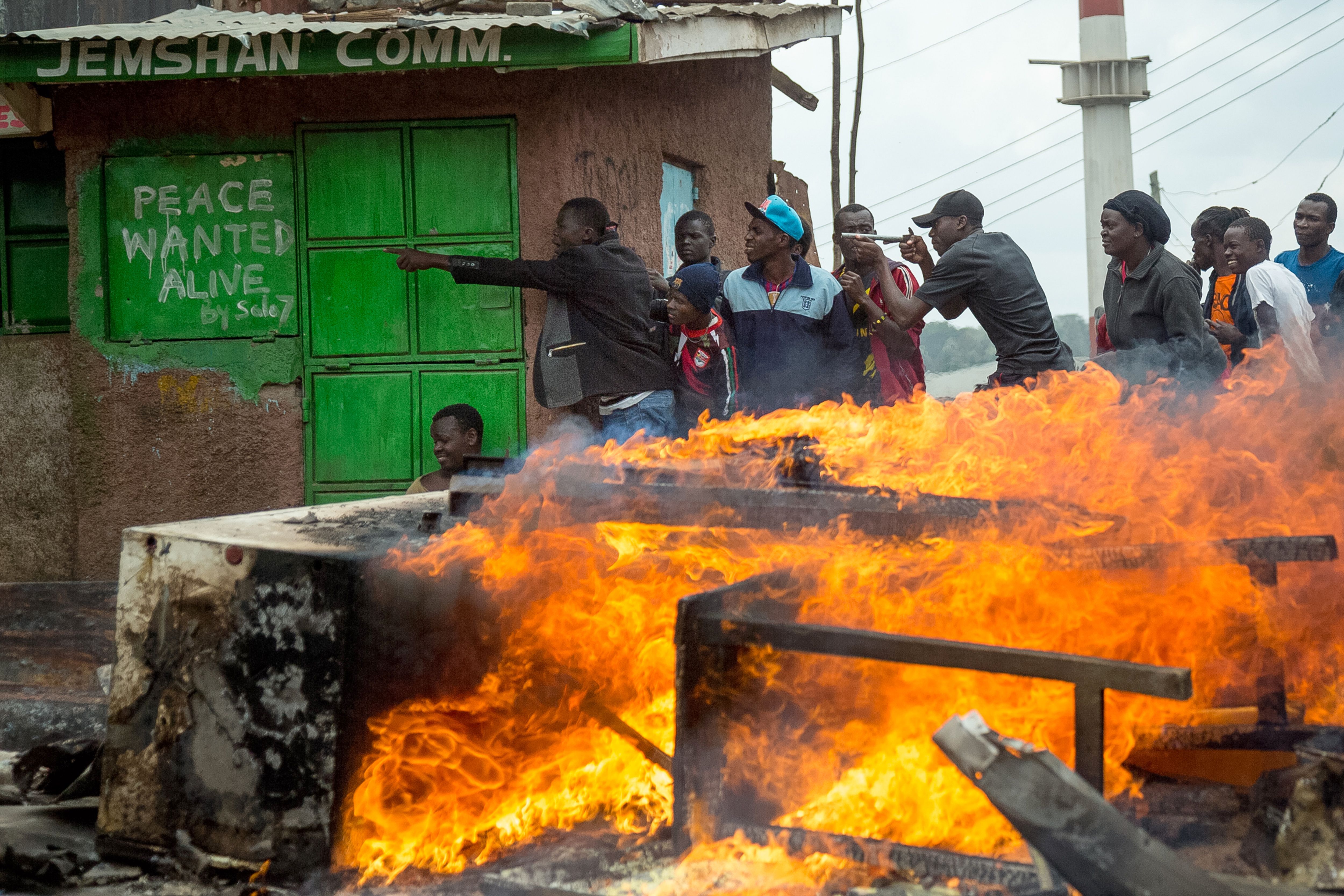 Supporters of Kenya's opposition party take shelter during a demonstration in Nairobi on November 20th, 2017, after Kenya's supreme court dismissed petitions to overturn the country's presidential election re-run, validating the poll victory of President Uhuru Kenyatta.