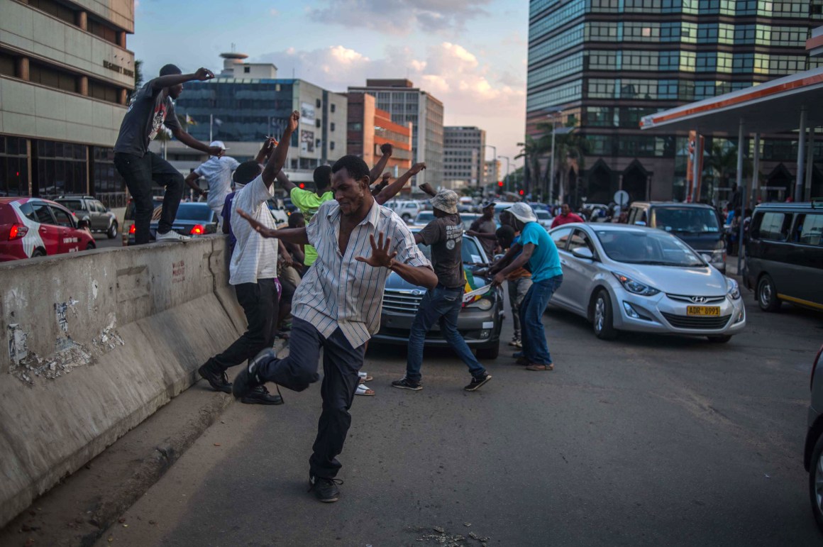 Harare residents celebrate in the streets following the resignation of Zimbabwe's president Robert Mugabe on November 21st, 2017. Mugabe, an autocrat who has ruled Zimbabwe since independence, agreed to step down a week after the military took control and moved to impeach him.