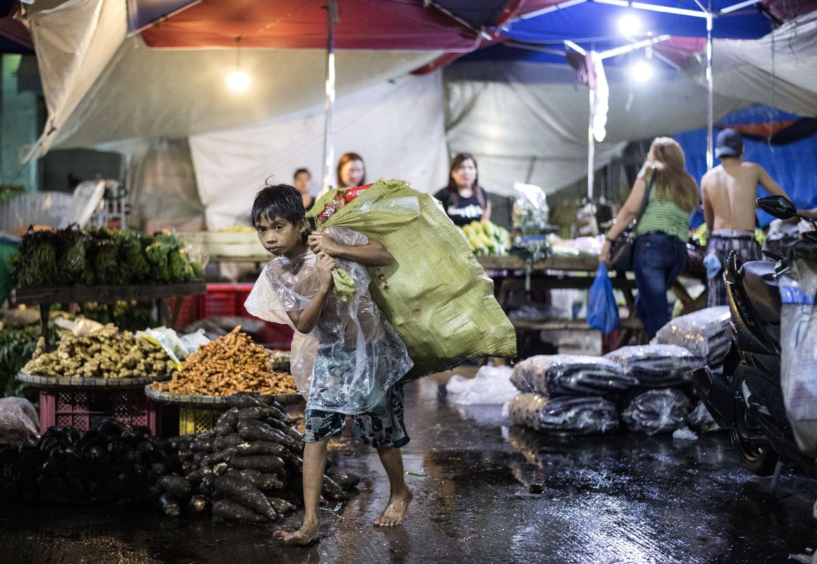 A boy collects used plastic bottles to be sold at a junk shop at Divisoria market in Manila, Philippines, on November 29th, 2017.