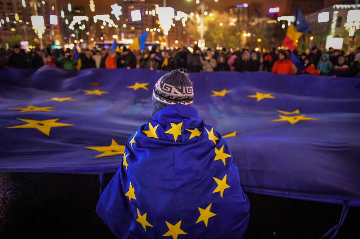 Protesters hold a European Union flag during an anti-government and corruption protest at the Victoria square in front of the Romanian government headquarters, in Bucharest, on December 3rd, 2017.