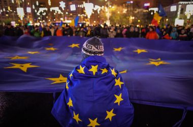 Protesters hold a European Union flag during an anti-government and corruption protest at the Victoria square in front of the Romanian government headquarters, in Bucharest, on December 3rd, 2017.