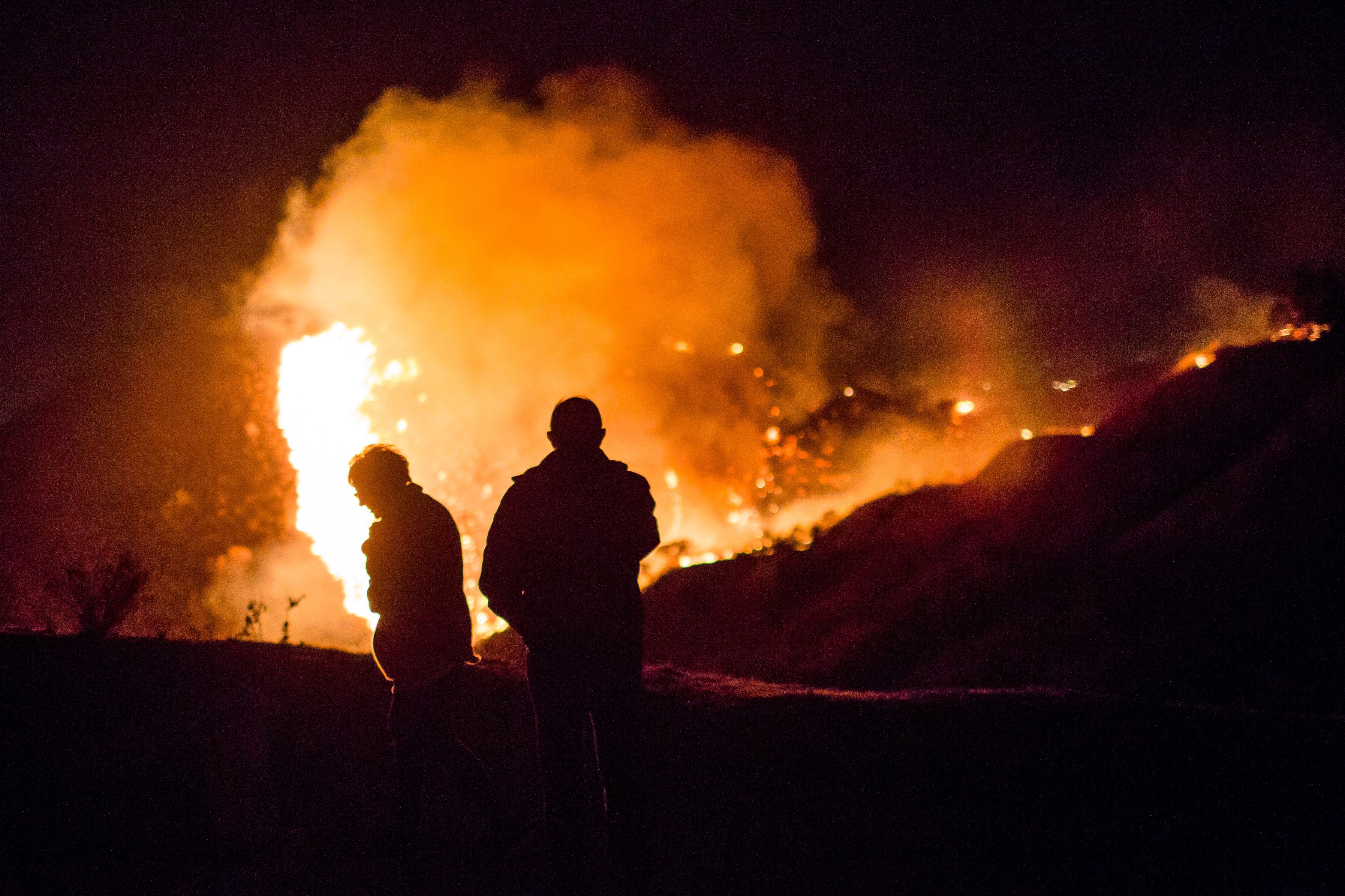 Spectators watch as the Creek Fire burns along a hillside near homes in the Shadow Hills neighborhood of Los Angeles, California.