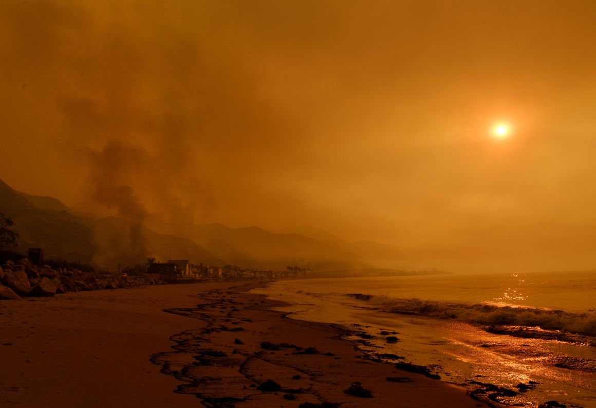 Heavy smoke covers the seaside enclave of Mondos Beach beside the 101 highway as flames reach the coast during the Thomas wildfire near Ventura, California, on December 6th, 2017.