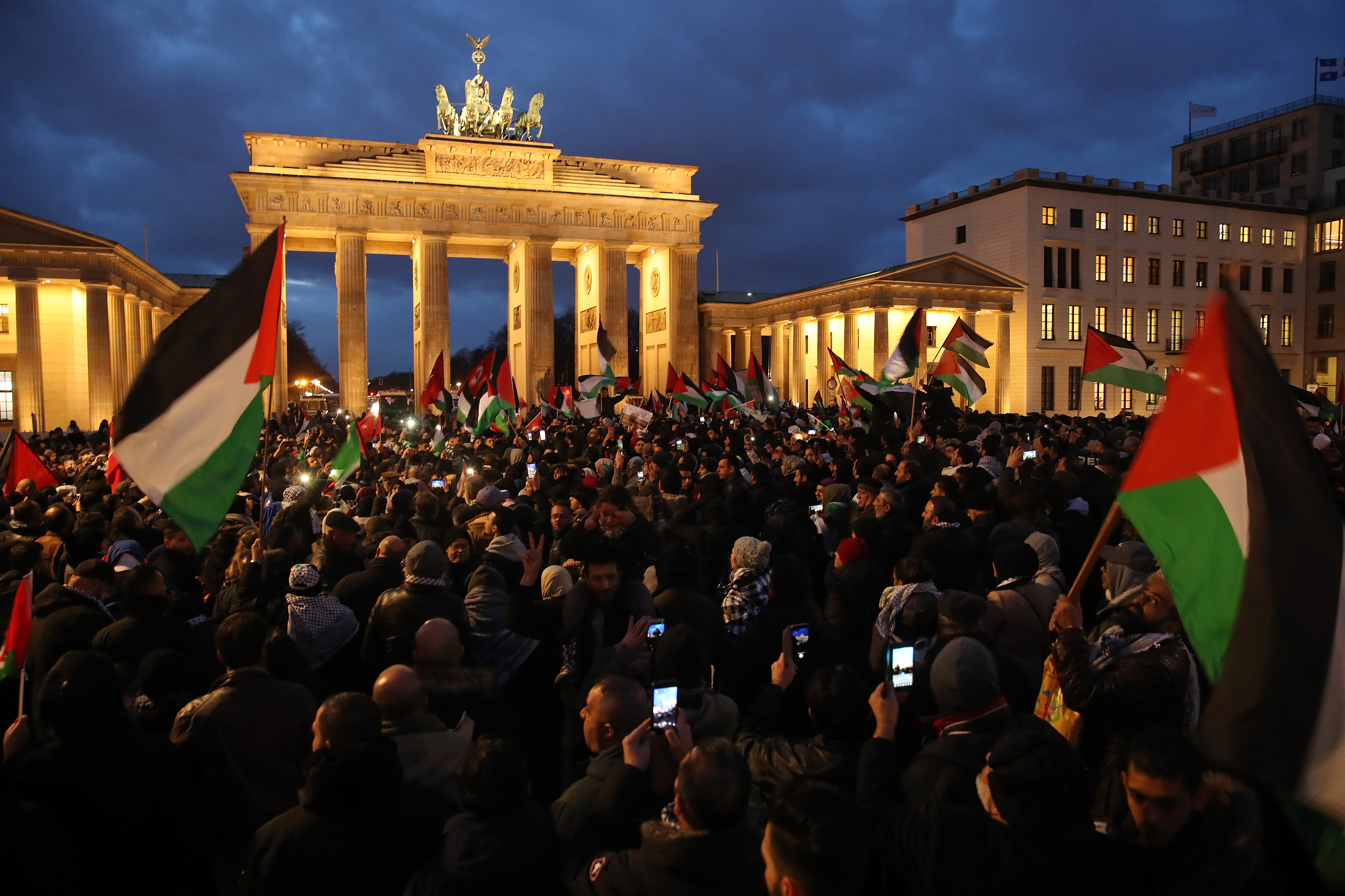 People waving Palestinian and Turkish flags gather in front of the Brandenburg Gate to protest against U.S. President Donald Trump's announcement to recognize Jerusalem as the capital of Israel on December 8th, 2017, in Berlin, Germany.