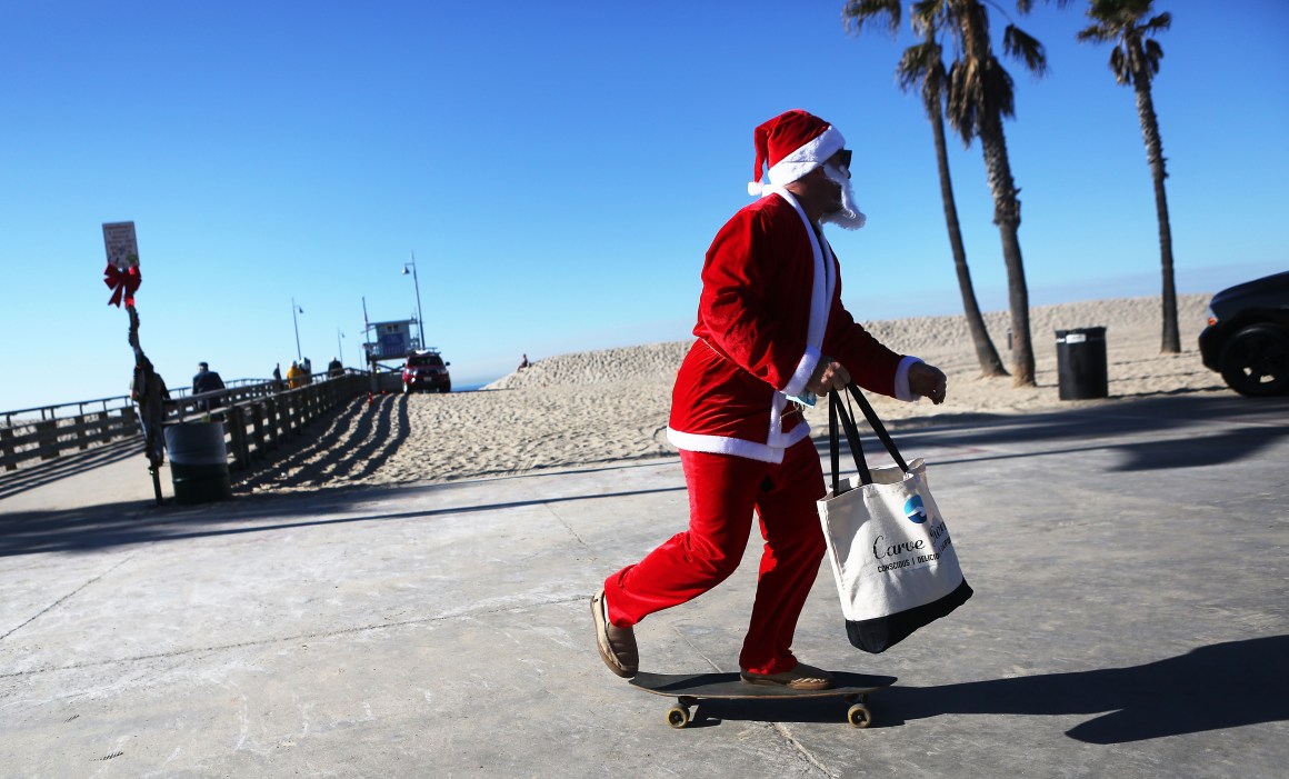 Jake Glaser, dressed as Santa Claus, skateboards at Venice Beach on December 13th, 2017, in Los Angeles, California. Residents are preparing for Christmas in the wake of a series of destructive wildfires across Southern California.