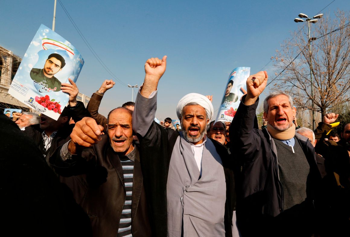 Iranian pro-government protesters, holding up portraits of Sajjad Shahsanai, a young member of the Revolutionary Guards killed in unrest in the city of Najafabad, shout slogans during a march after the weekly Friday prayers in Tehran on January 5th, 2018.