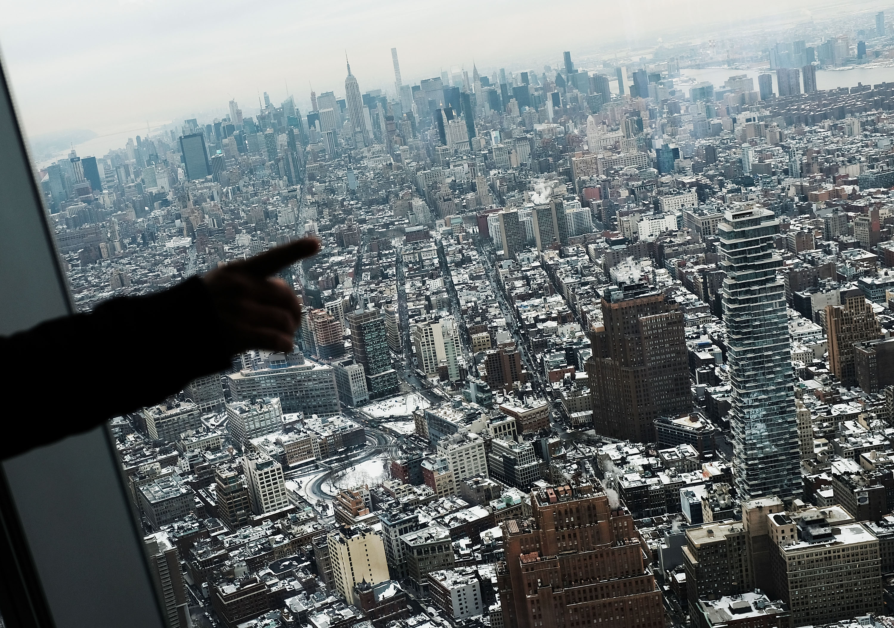 Visitors to the One World Observatory look out at a snow covered Manhattan on January 8th, 2018, in New York City.