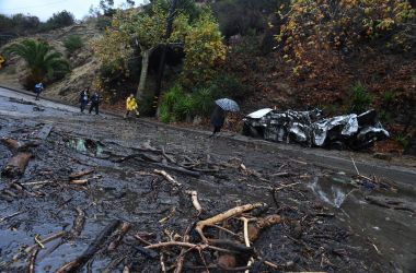 A firefighter instructs journalists to retreat to safer ground after a rain-driven mudslide destroyed two cars and damaged property in a neighborhood under mandatory evacuation in Burbank, California, January 9th, 2018.