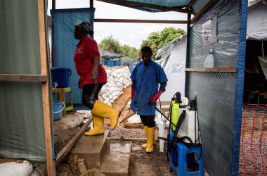 A worker at an emergency cholera treatment center gets her shoes disinfected in Kinshasa, the Democratic Republic of the Congo, on January 18th, 2018. The World Health Organization said this week that there was a high risk of a cholera epidemic after flooding in the area.