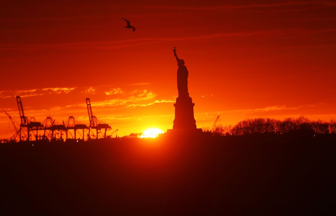 The Statue of Liberty stands in New York Harbor at sunset on January 23rd, 2018, in New York City.