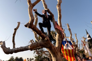 A demonstrator covers his face with a mask depicting ousted separatist leader Carles Puigdemont during a protest outside the Catalan parliament on January 30th, 2018, in Barcelona, Spain. The Parliament delayed a key debate in the regional assembly on Puigdemont's bid to form a new government, but defended his right to return to power.