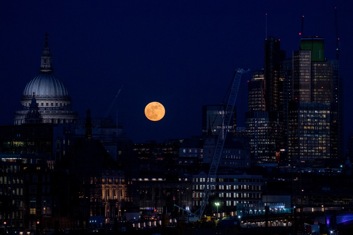 A supermoon rises behind St. Paul's Cathedral and skyscrapers on January 31st, 2018, in London, United Kingdom. The Super Blue Blood Moon is a rare simultaneous combination of a supermoon, a blood moon, and a blue moon.