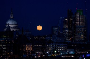 A supermoon rises behind St. Paul's Cathedral and skyscrapers on January 31st, 2018, in London, United Kingdom. The Super Blue Blood Moon is a rare simultaneous combination of a supermoon, a blood moon, and a blue moon.