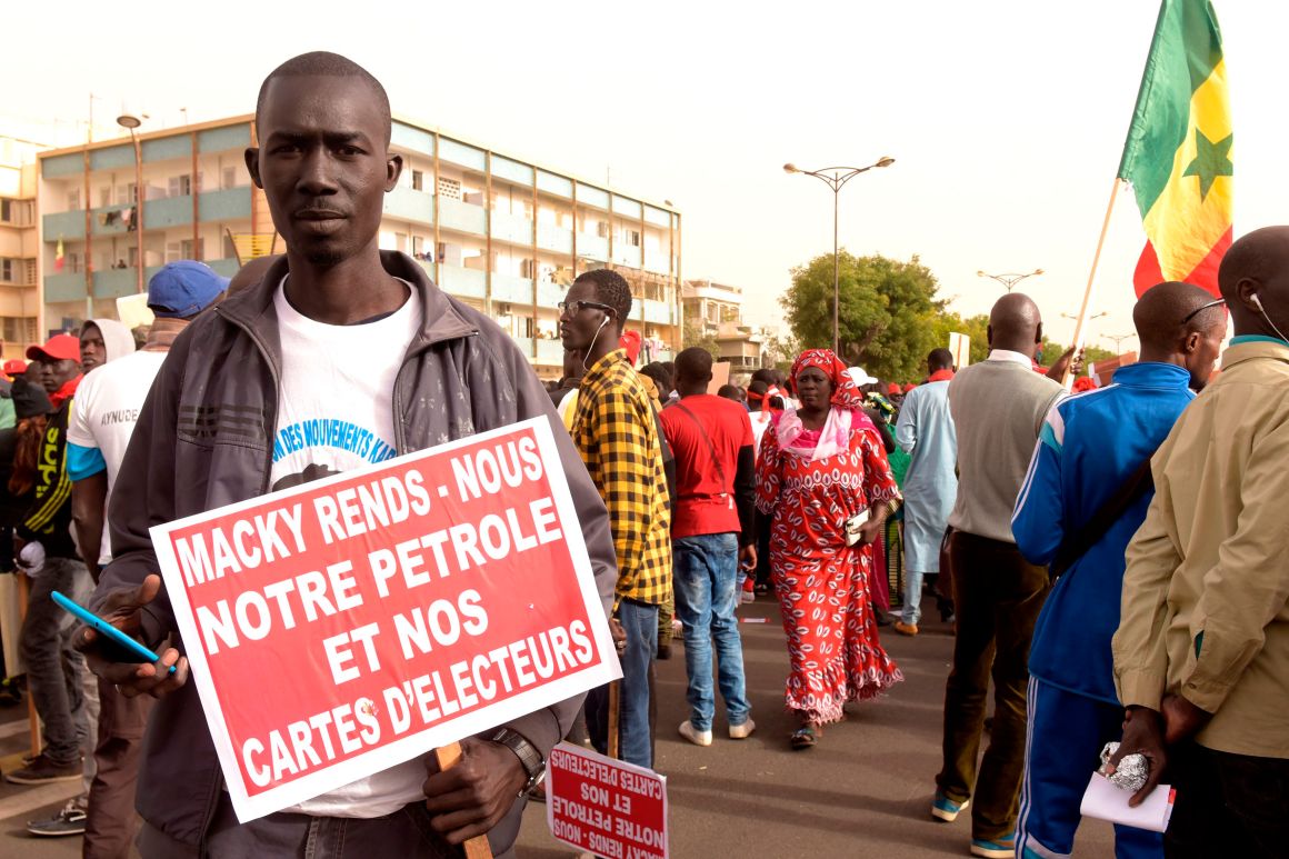 A man carries a placard demanding election rights during a demonstration by opposition parties for free and transparent elections on February 9th, 2018, in Dakar, Senegal. Senegal's presidential elections will be held in 2019.