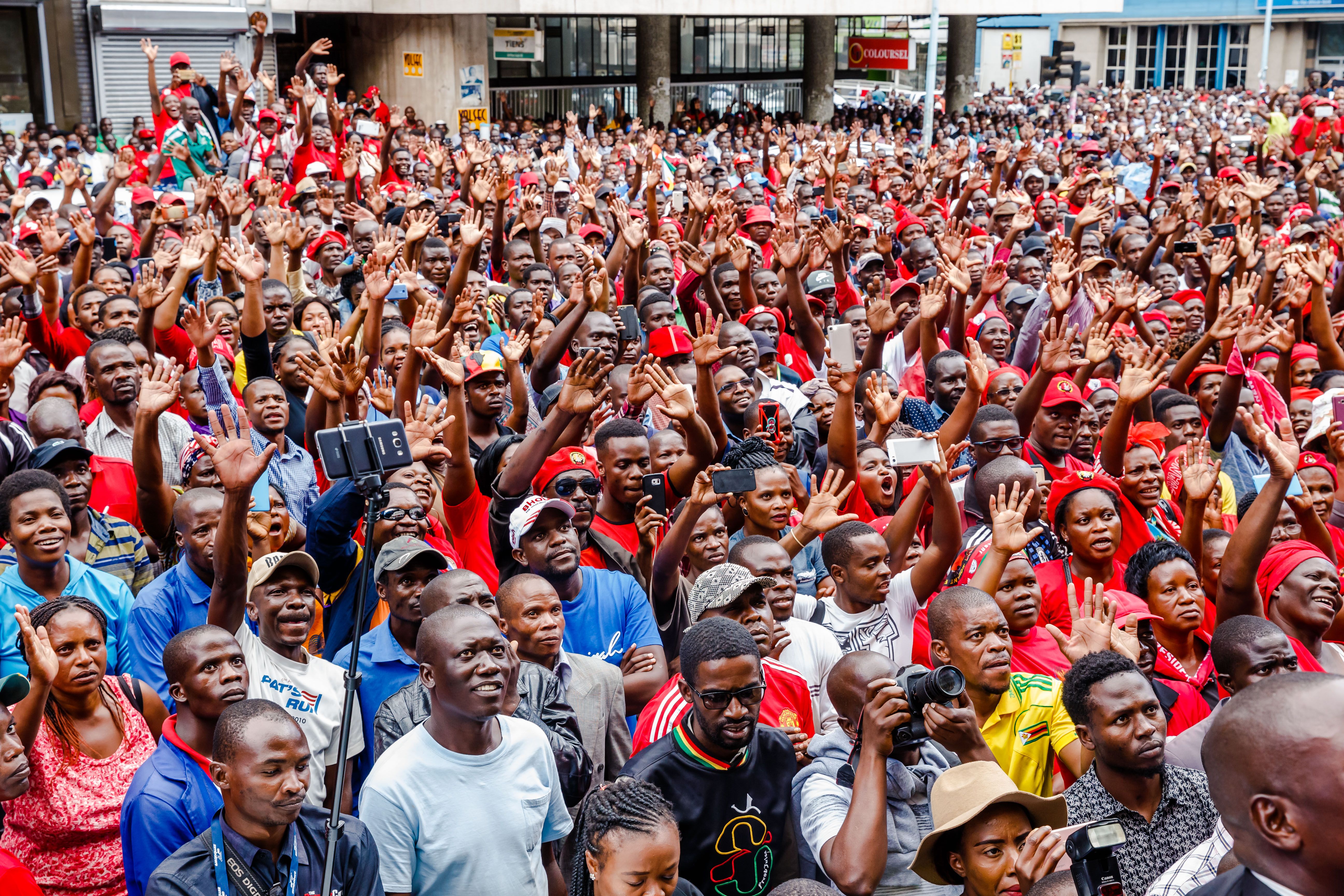 Supporters of the Zimbabwe opposition party, the Movement for Democratic Change, listen and cheer as the party's acting president addresses the crowd gathered outside the party headquarters in Harare, Zimbabwe, on February 15th, 2018, following the death of the former opposition leader, Morgan Tsvangirai.