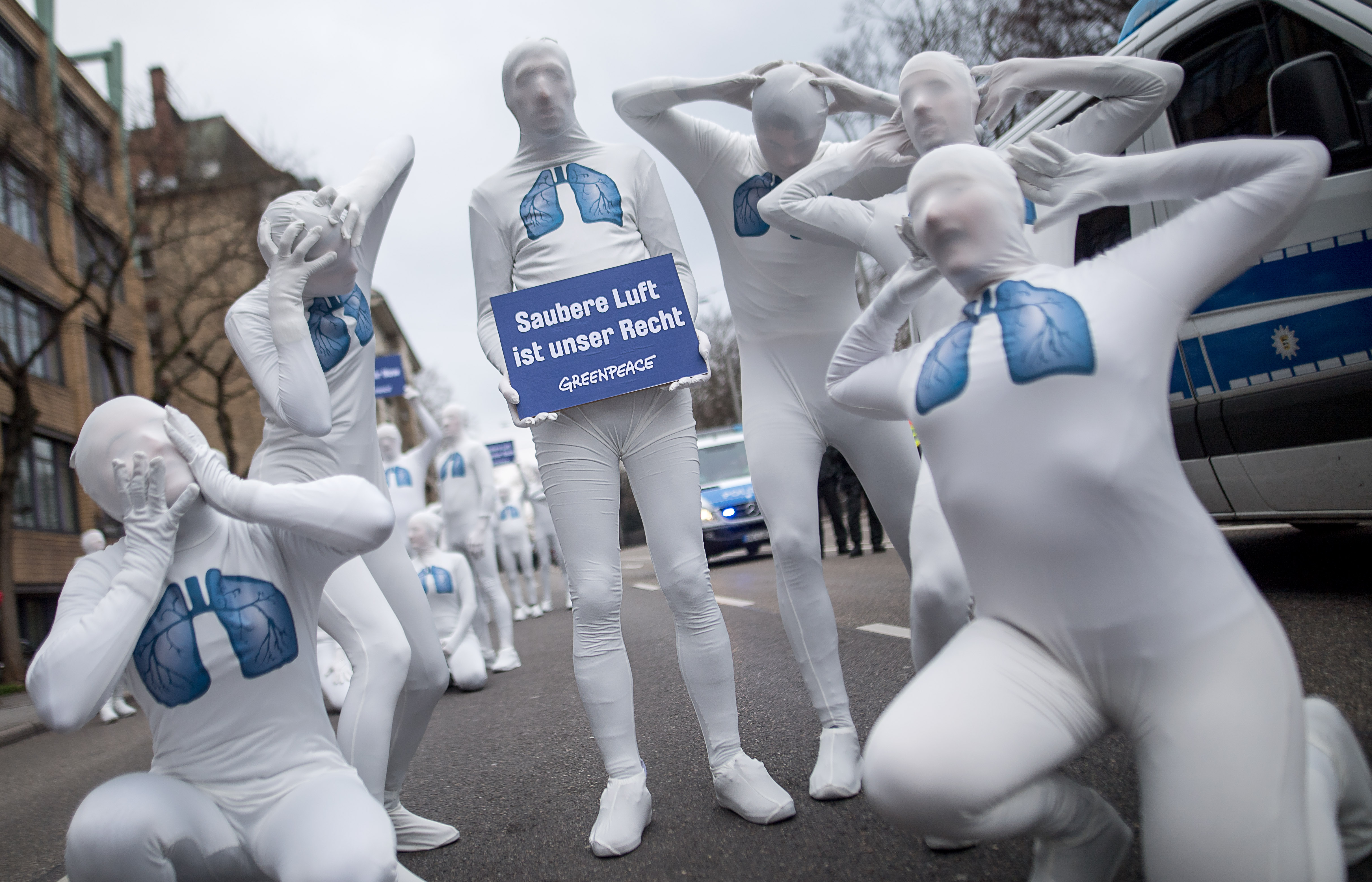 Greenpeace activists hold a poster reading 