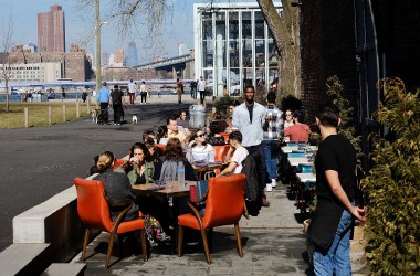 People eat outside in a Brooklyn neighborhood.