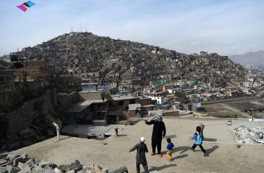 An Afghan man and children play with a kite on a rooftop overlooking Kabul, the capital city of Afghanistan, on February 23rd, 2018.