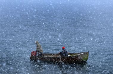 Fishermen row through heavy snowfall as they return to the shores of Lake Ohrid in Pogradec, Albania, on February 27th, 2018. Heavy snow and low temperatures have hit the Balkan countries, including Albania, causing problems for the traffic and power supply.