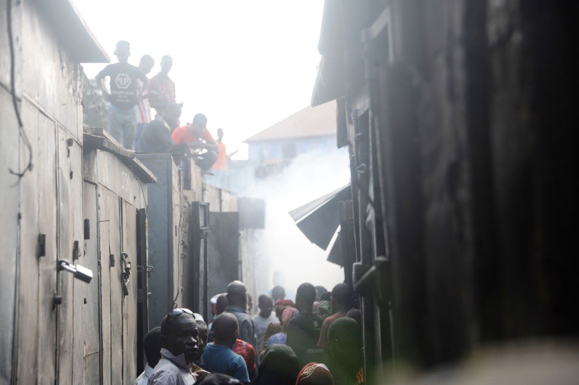 People walk in an alley of the Marché Medina market, in Conakry, Guinea, on March 18th, 2018, after it was devastated by a fire.