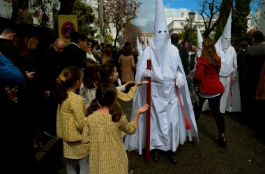 Children ask for candy from members of the La Paz brotherhood as they head to church to take part in the Palm Sunday procession in Sevilla, Spain, on March 25th, 2018.