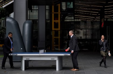 A woman walks past two men playing table tennis outside the Leadenhall Building as the deadline nears for companies to report their gender pay gap on April 4th, 2018, in London, England.