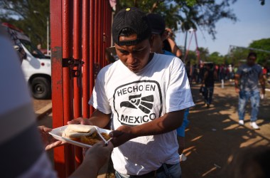 Central-American migrants taking part in the "Migrant Via Crucis" caravan toward the United States receive breakfast as they camp at a sport complex in Matias Romero, Oaxaca State, Mexico.